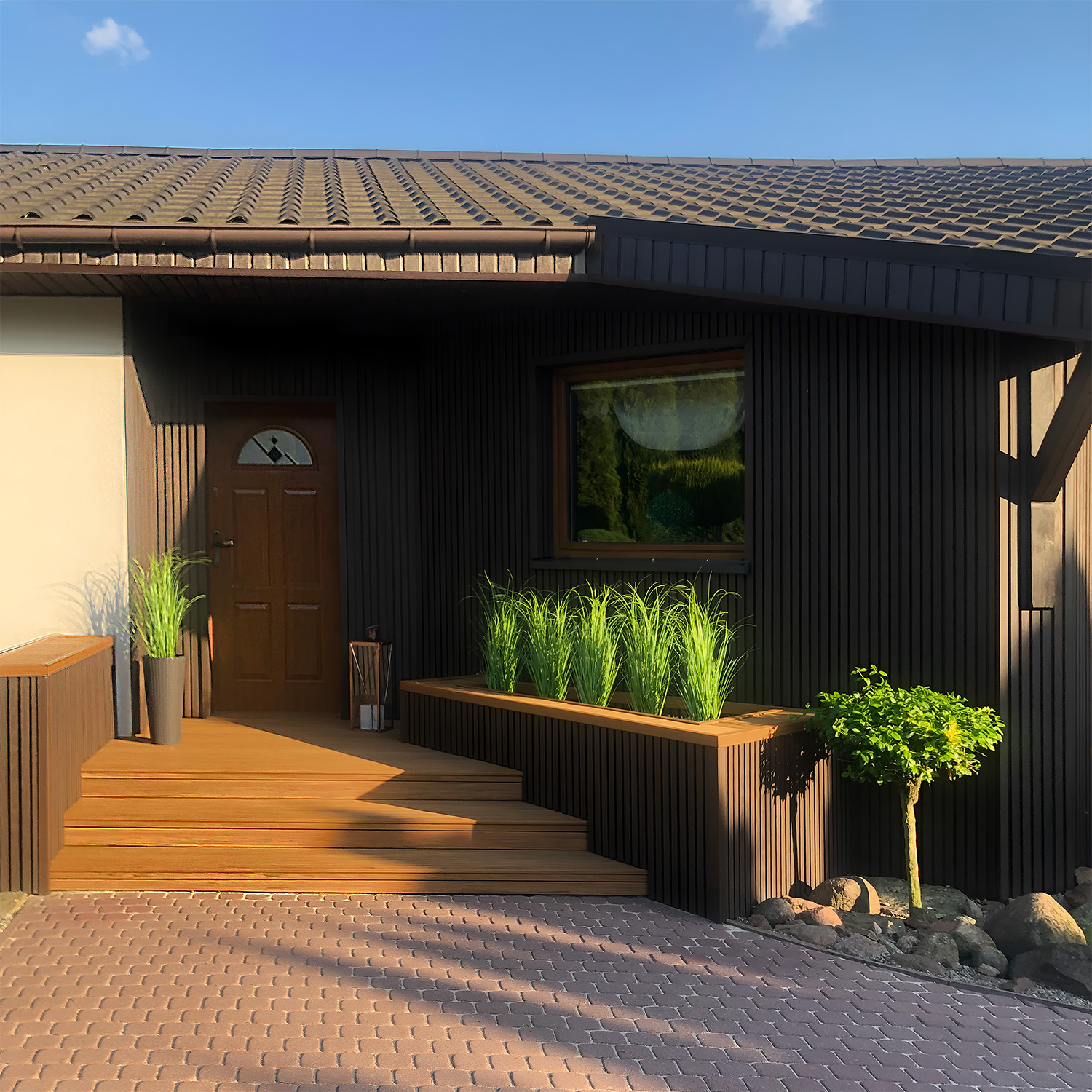 Kompozitinė terasa ir fasadas: lamelės 3D Premium Walnut ir terasinė lenta Premium Amber